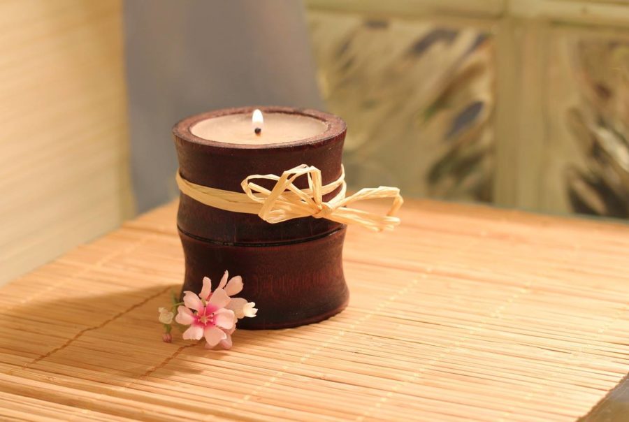 Lit candle on natural wood table